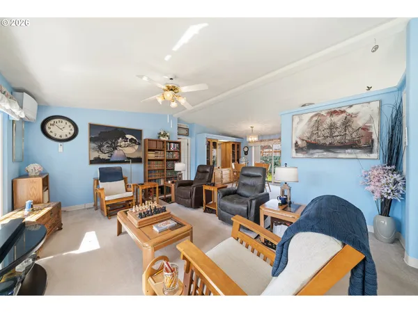 a living room with furniture kitchen view and painting on the wall