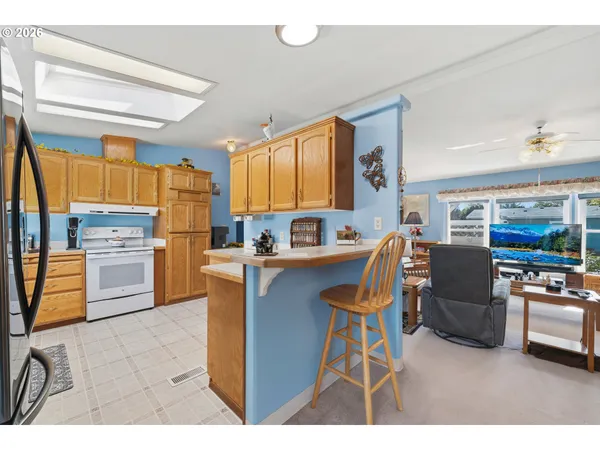a living room with stainless steel appliances kitchen island granite countertop furniture and a view of kitchen