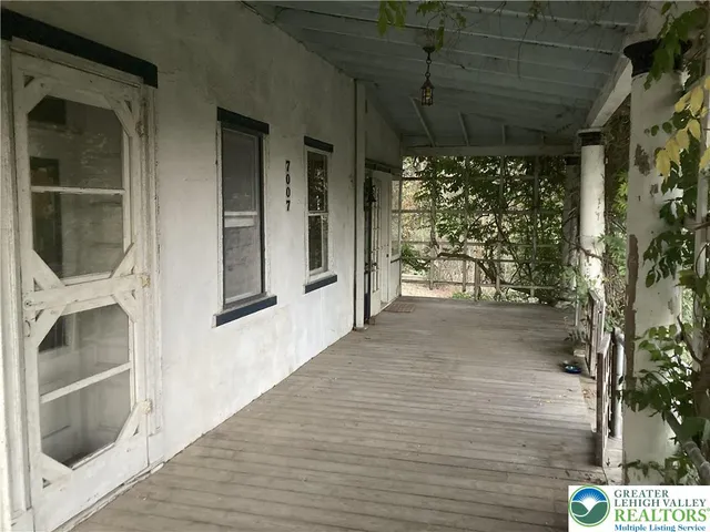 a view of a porch with wooden floor and a potted plant