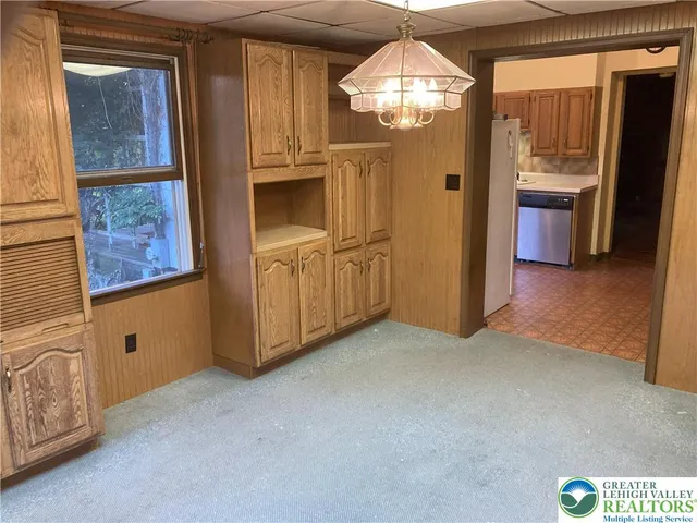 a view of an empty room with a fireplace and a chandelier