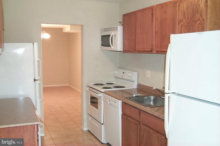 12712 Veirs Mill Road, Unit 843 Rockville, MD 20853 - Photo 4 of 10 a kitchen with a stove and a microwave
