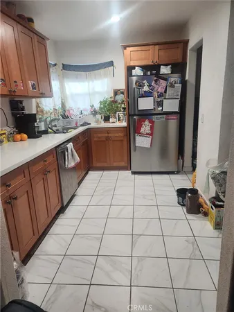 a kitchen with stainless steel appliances a sink a stove a refrigerator a window