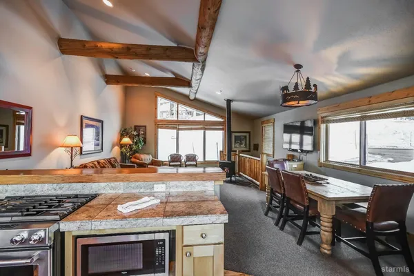 a kitchen with stainless steel appliances granite countertop a stove a sink and a microwave