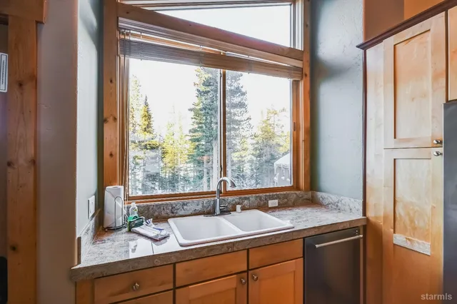 a kitchen with stainless steel appliances granite countertop a refrigerator a stove and a wooden floors