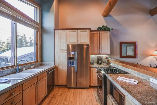 a kitchen with stainless steel appliances granite countertop a refrigerator and a stove