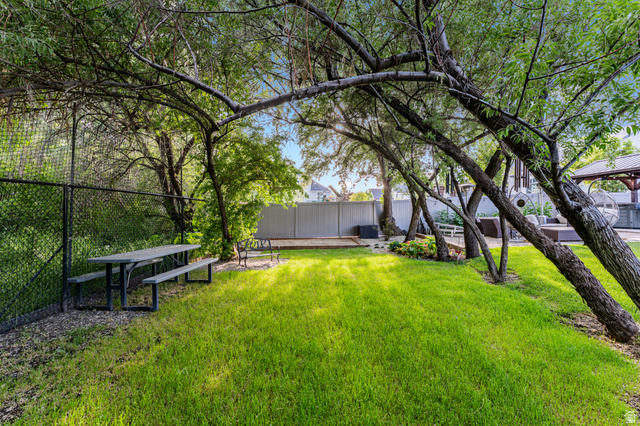 313 Old Maple Road South Weber, UT 84405 - Photo 33 of 35 Expansive green space featuring mature trees, a picnic table, and a chain-link fence