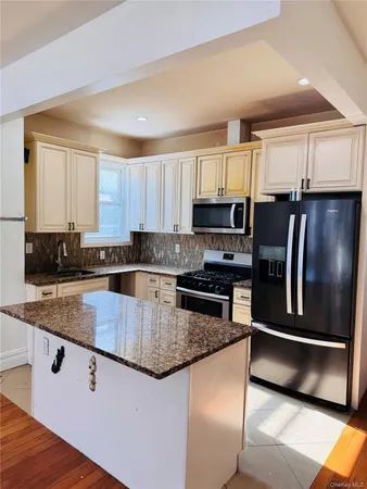 a kitchen with stainless steel appliances granite countertop a stove a sink and a microwave