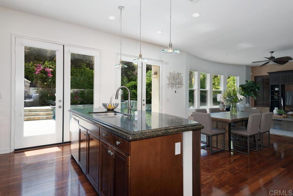 5473 Valerio Trail San Diego, CA 92130 - Photo 12 of 39 a kitchen with stainless steel appliances granite countertop a sink and wooden floor