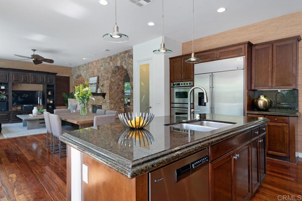 5473 Valerio Trail San Diego, CA 92130 - Photo 13 of 39 a kitchen with granite countertop a sink a counter top space and living room view