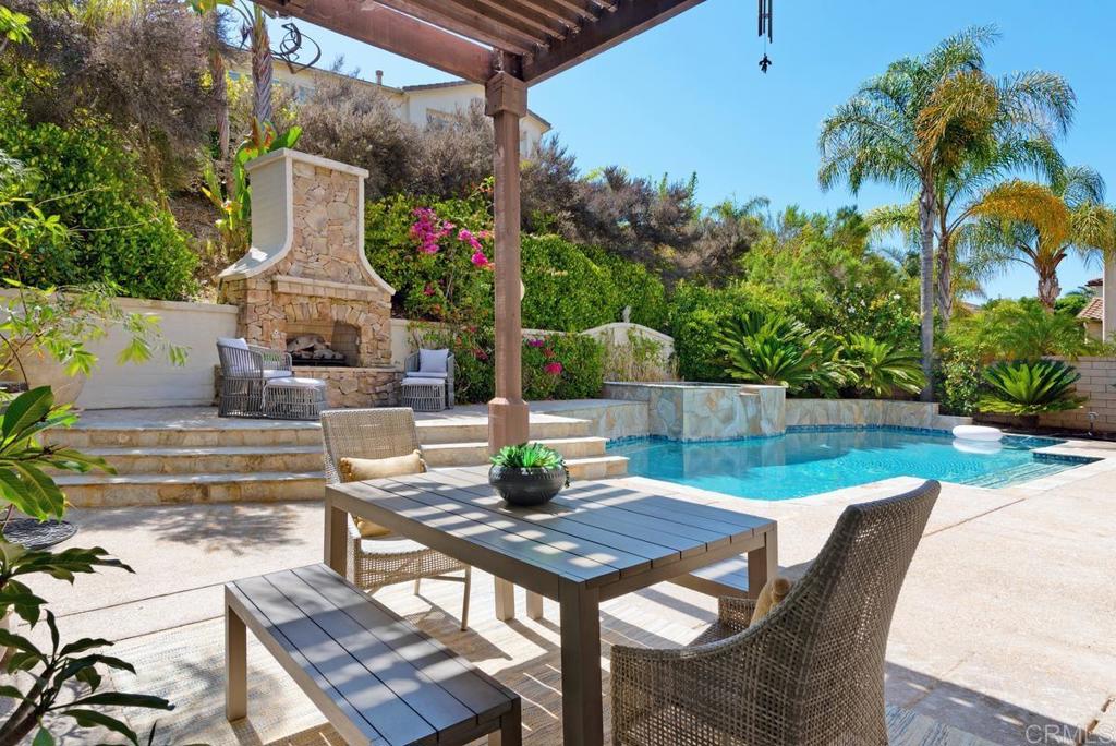 5473 Valerio Trail San Diego, CA 92130 - Photo 36 of 39 a view of a patio with table and chairs potted plants with palm trees
