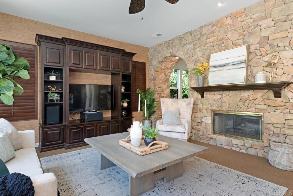 5473 Valerio Trail San Diego, CA 92130 - Photo 7 of 39 a living room with furniture a fireplace and a floor to ceiling window