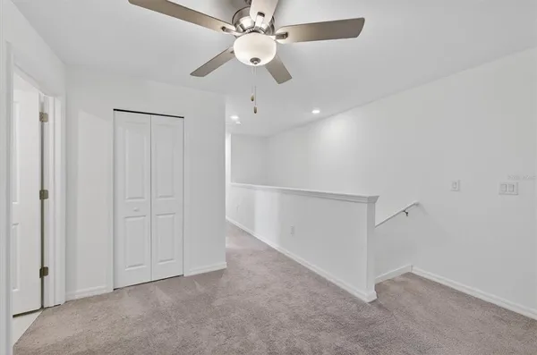 an empty room with fan ceiling fan and windows