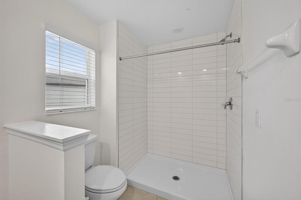 6956 Ripple Pond Loop Zephyrhills, FL 33541 - Photo 17 of 30 a bathroom with a shower a toilet and sink