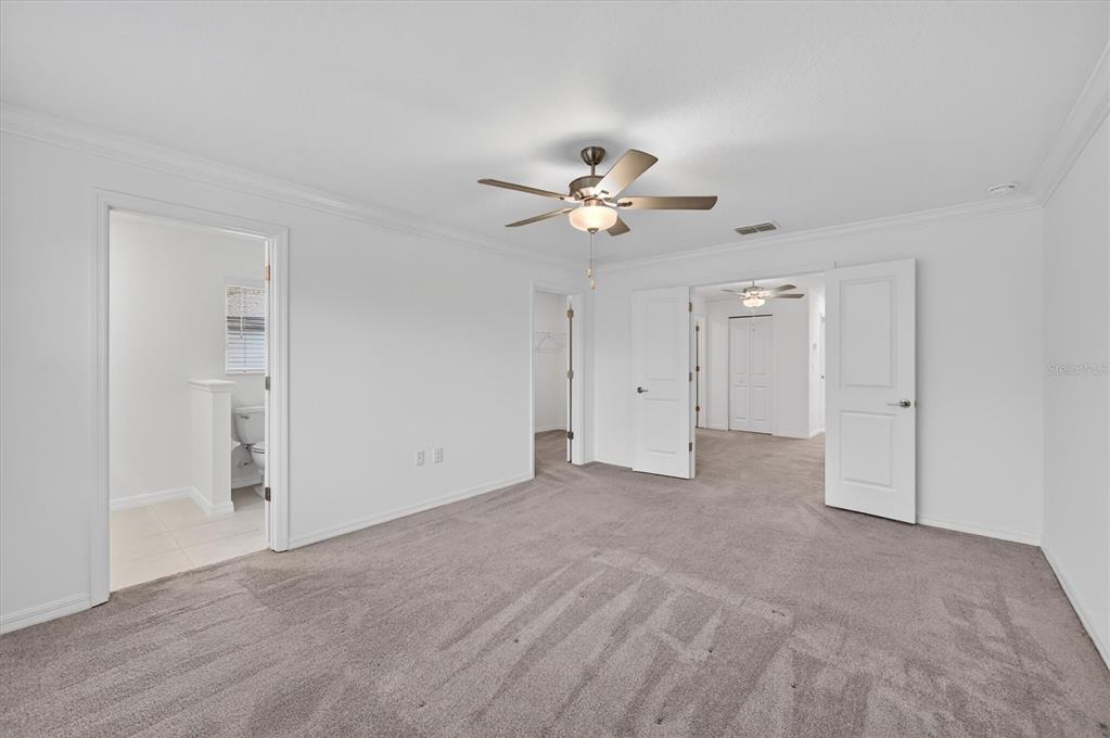 6956 Ripple Pond Loop Zephyrhills, FL 33541 - Photo 18 of 30 a view of an empty room with a ceiling fan