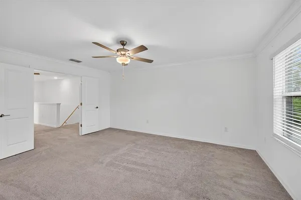 an empty room with a window and a fan