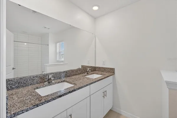 a bathroom with a granite countertop sink and vanity