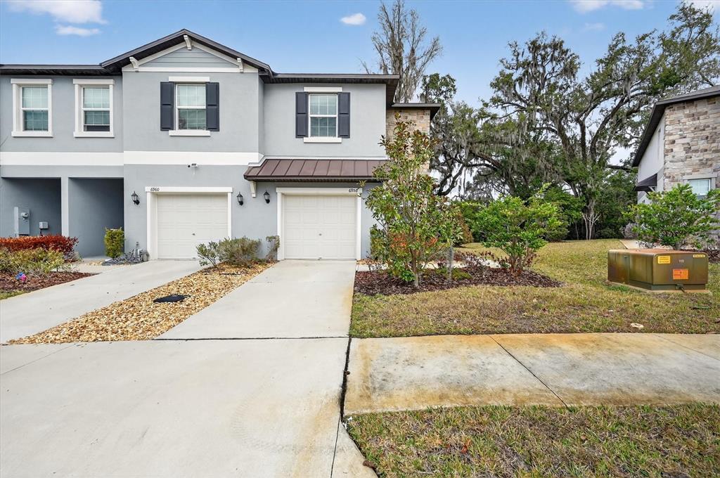 6956 Ripple Pond Loop Zephyrhills, FL 33541 - Photo 2 of 30 a front view of a house with a yard and garage