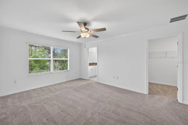 an empty room with a window and a fan