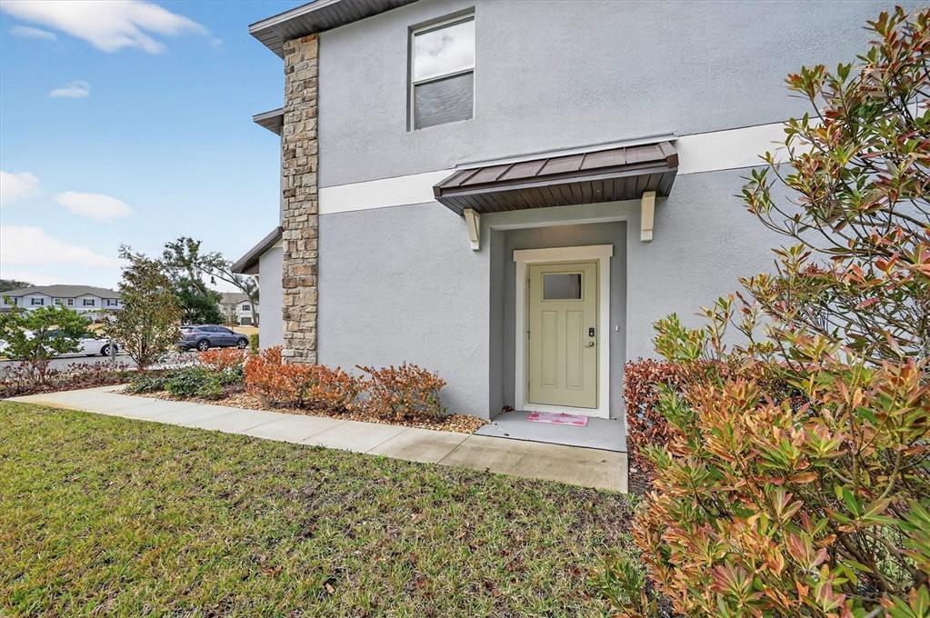 6956 Ripple Pond Loop Zephyrhills, FL 33541 - Photo 3 of 30 a view of a house with a small yard and plants