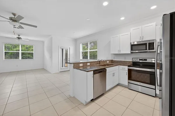 a kitchen with stainless steel appliances granite countertop a stove a sink and a microwave