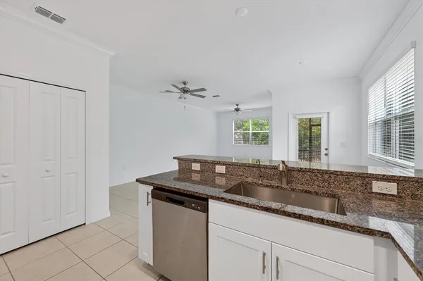 a kitchen with granite countertop a sink and a white cabinets