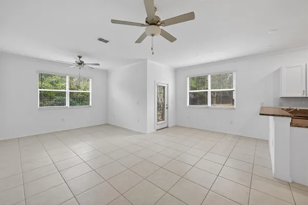 an empty room with ceiling fan and window