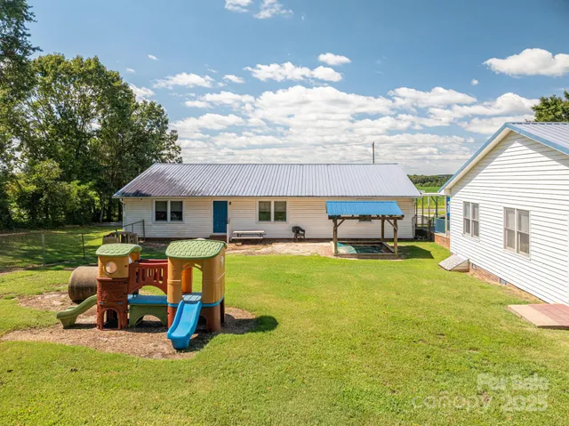 a view of a house with backyard and sitting area
