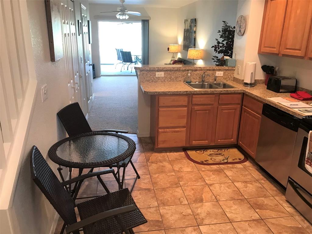 26386 Nadir Road, Unit 401 Punta Gorda, FL 33983 - Photo 4 of 42 a kitchen with a sink a stove and chairs