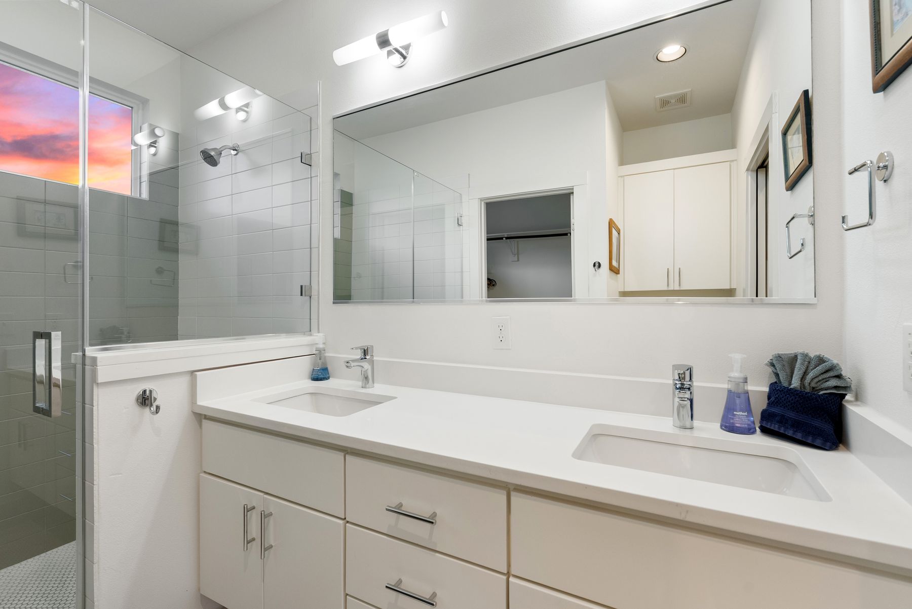 1709 Perez Street, Unit 2 Austin, TX 78721 - Photo 25 of 33 Double vanity sinks and a glass-enclosed shower create a practical, bright bathroom environment.