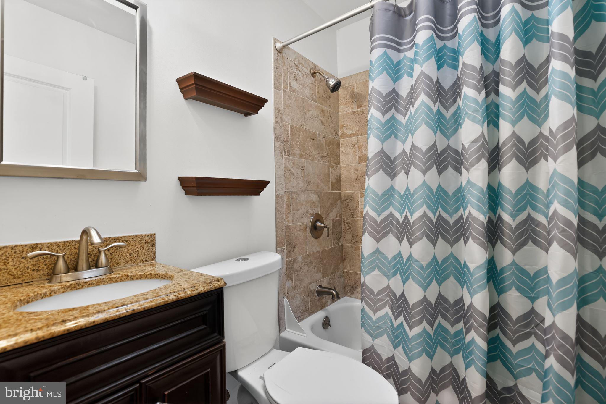 6843 Dunbar Road Baltimore, MD 21222 - Photo 11 of 27 a bathroom with a granite countertop sink and a toilet