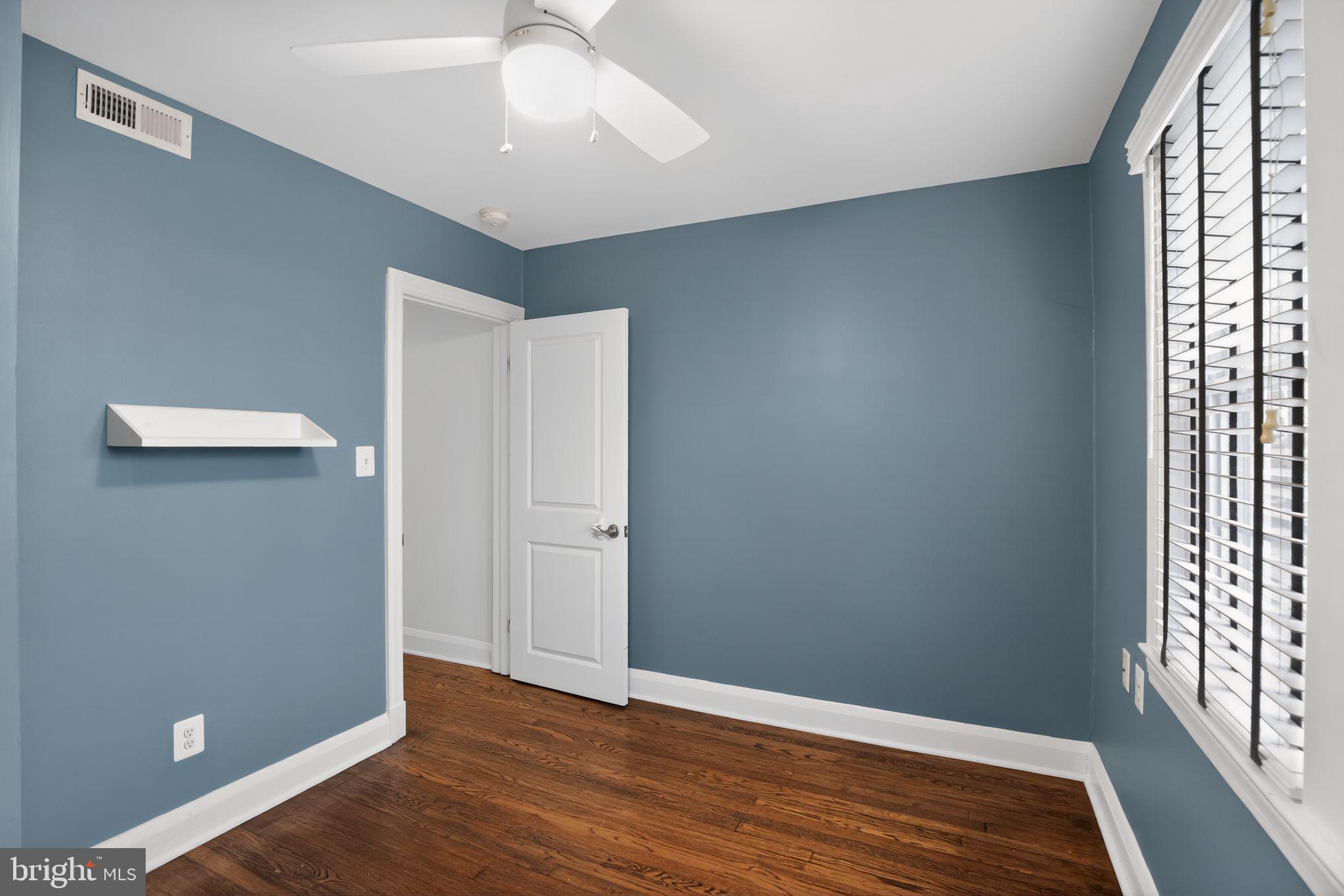 6843 Dunbar Road Baltimore, MD 21222 - Photo 17 of 27 an empty room with wooden floor and windows