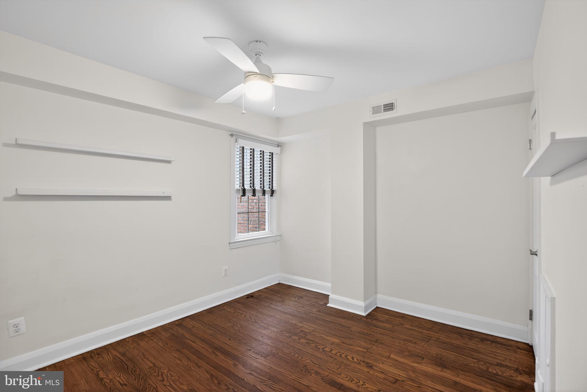6843 Dunbar Road Baltimore, MD 21222 - Photo 20 of 27 a view of an empty room with wooden floor and a window