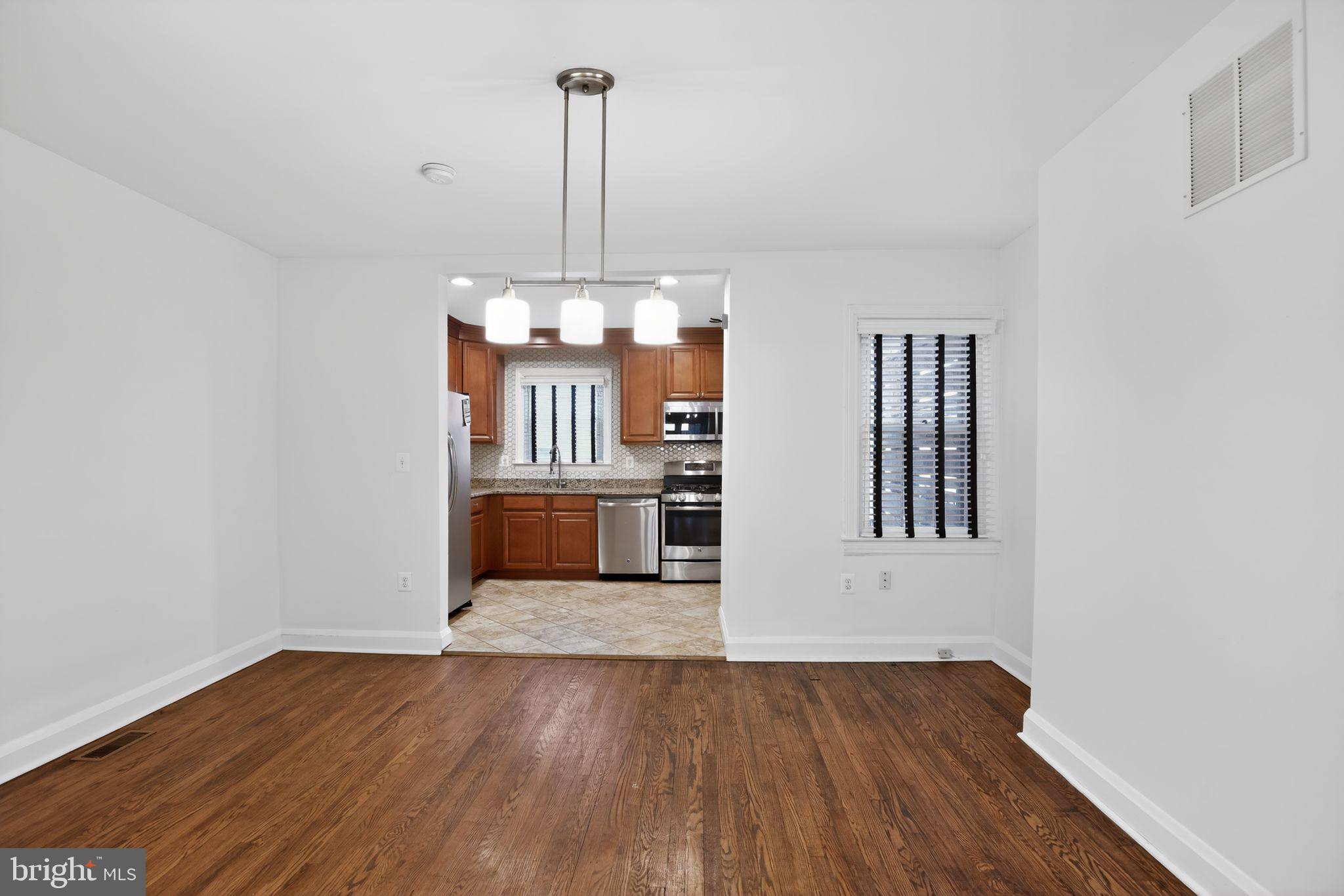6843 Dunbar Road Baltimore, MD 21222 - Photo 6 of 27 a view of a room with wooden floor kitchen view and a window
