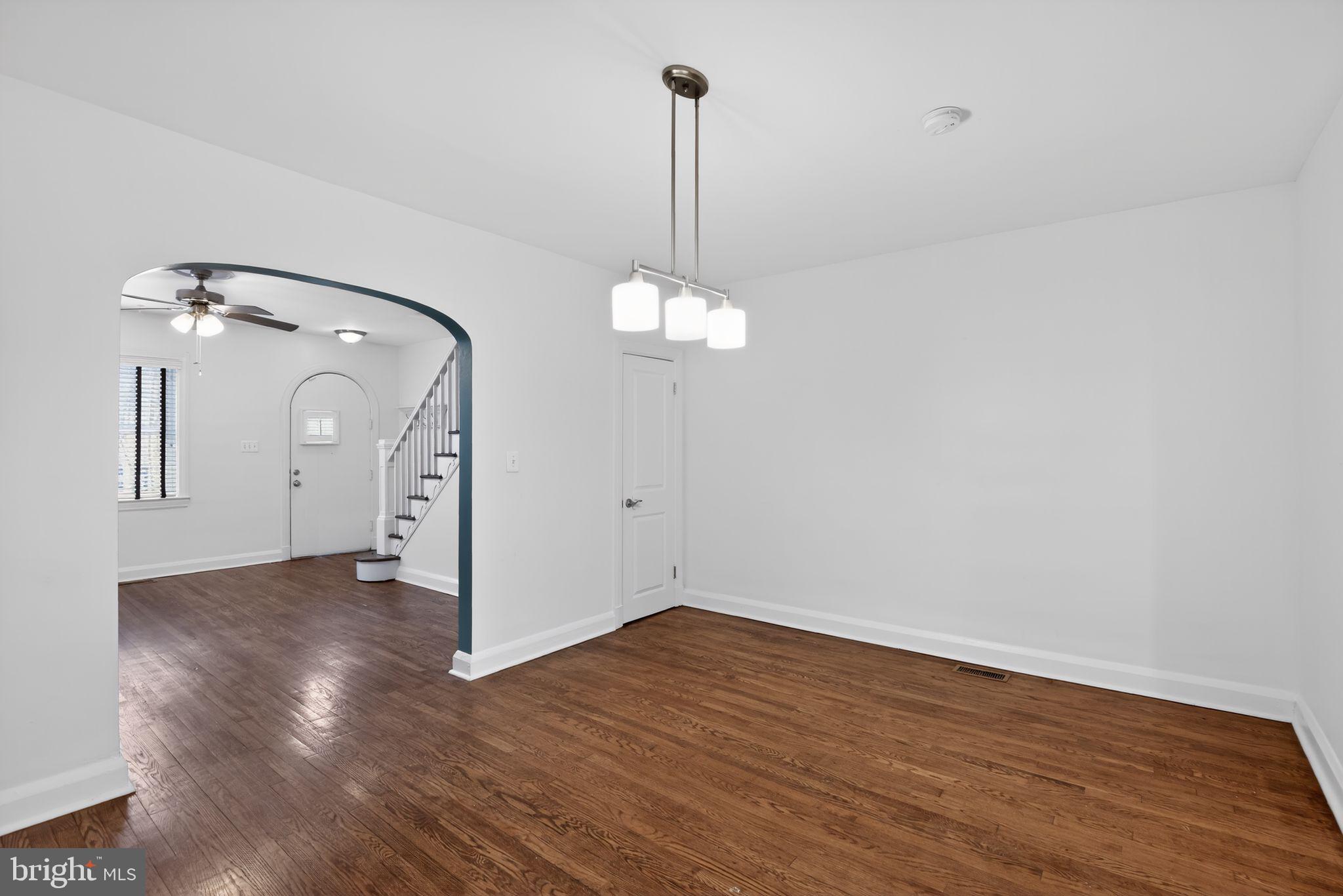6843 Dunbar Road Baltimore, MD 21222 - Photo 7 of 27 a view of a room with wooden floor staircase and a chandelier