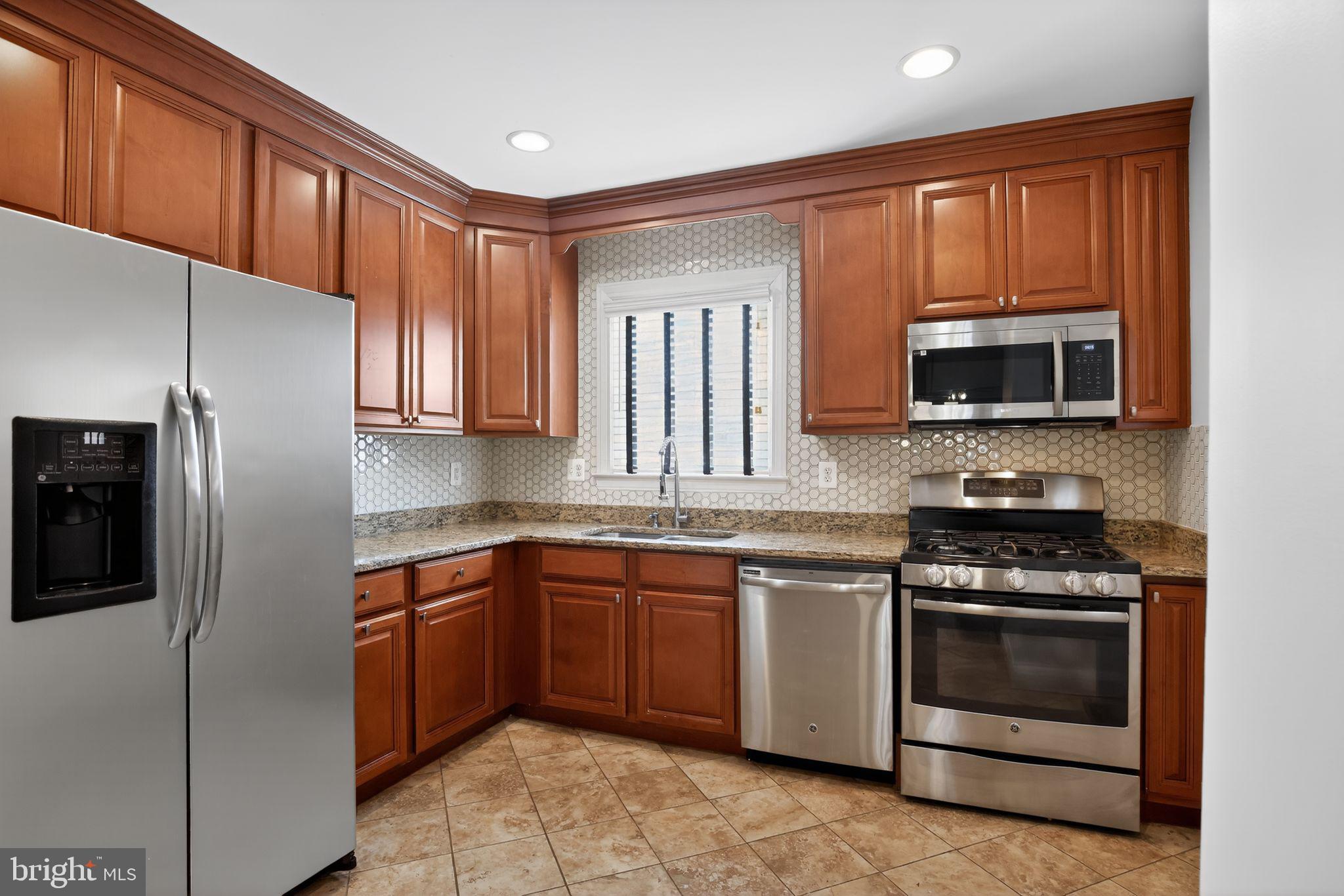 6843 Dunbar Road Baltimore, MD 21222 - Photo 10 of 27 a kitchen with stainless steel appliances granite countertop a stove microwave and refrigerator