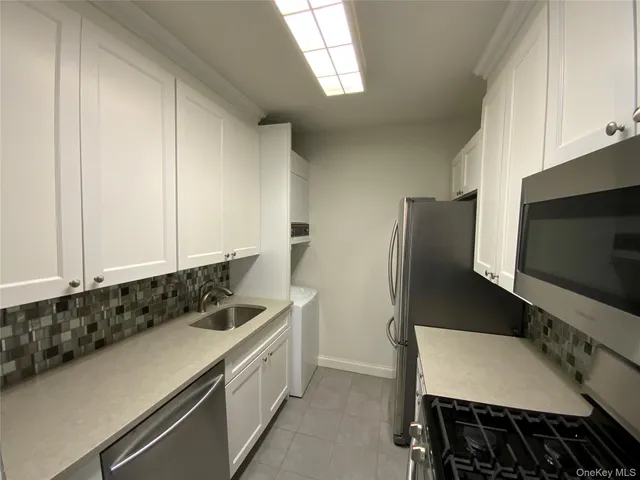 a kitchen with stainless steel appliances a stove a microwave a sink and cabinets