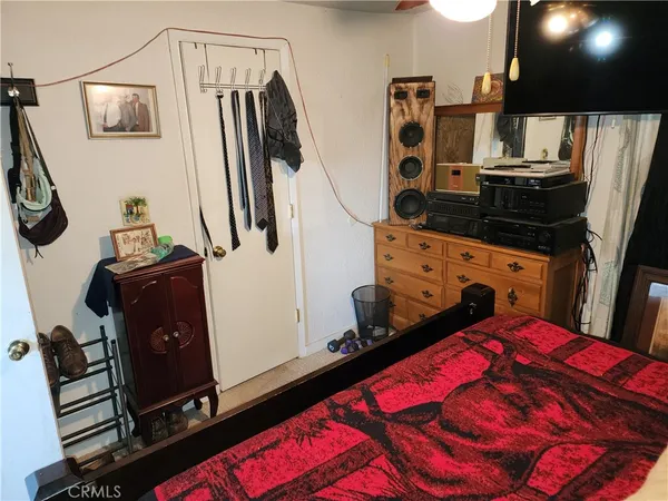 a bedroom with a bed and flat tv screen on the dresser