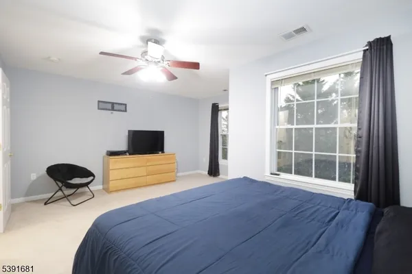 a bedroom with a bed and a large window
