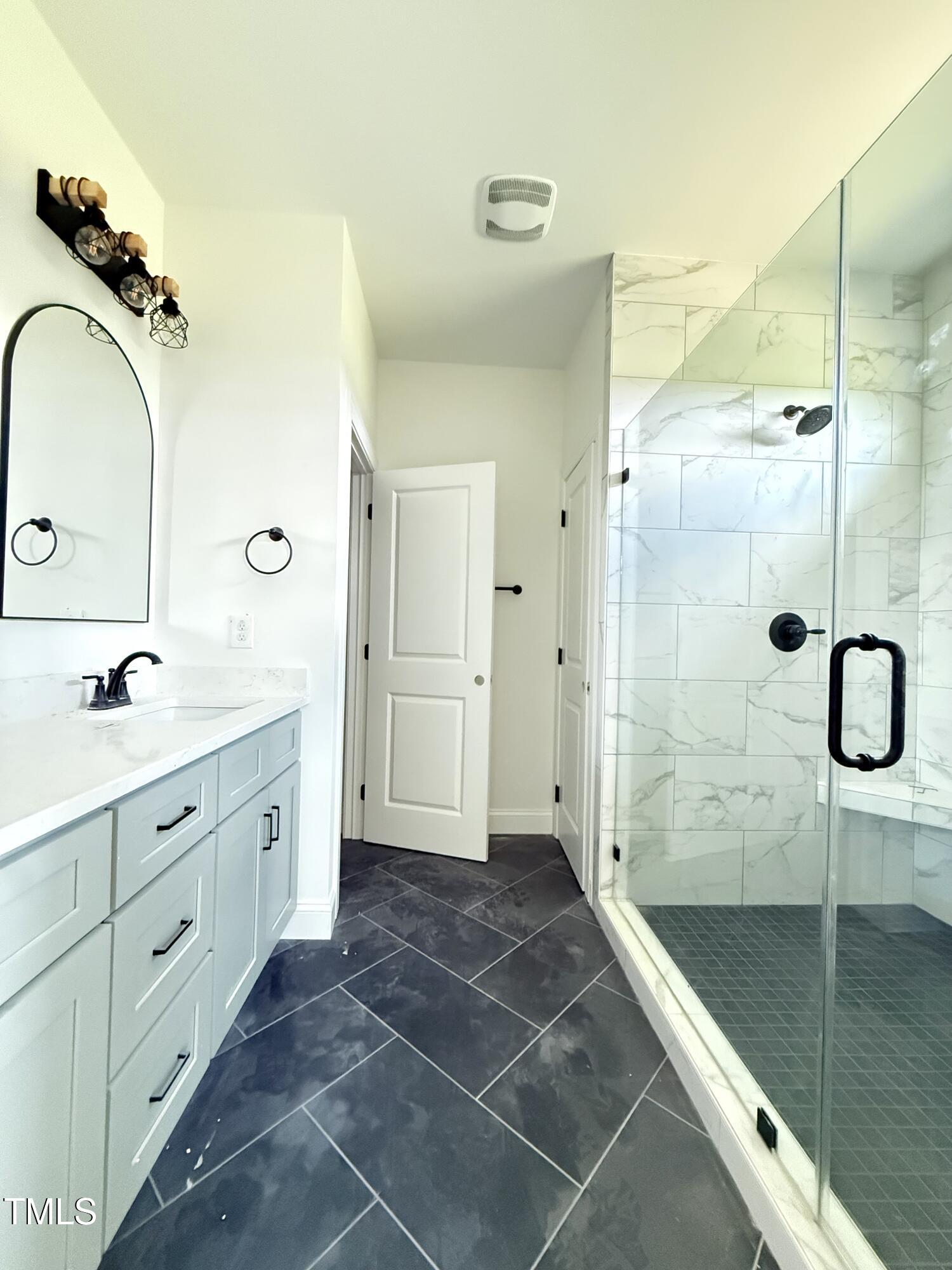 6930 Fire Tower Road Spring Hope, NC 27882 - Photo 14 of 33 a bathroom with a granite countertop sink mirror and shower