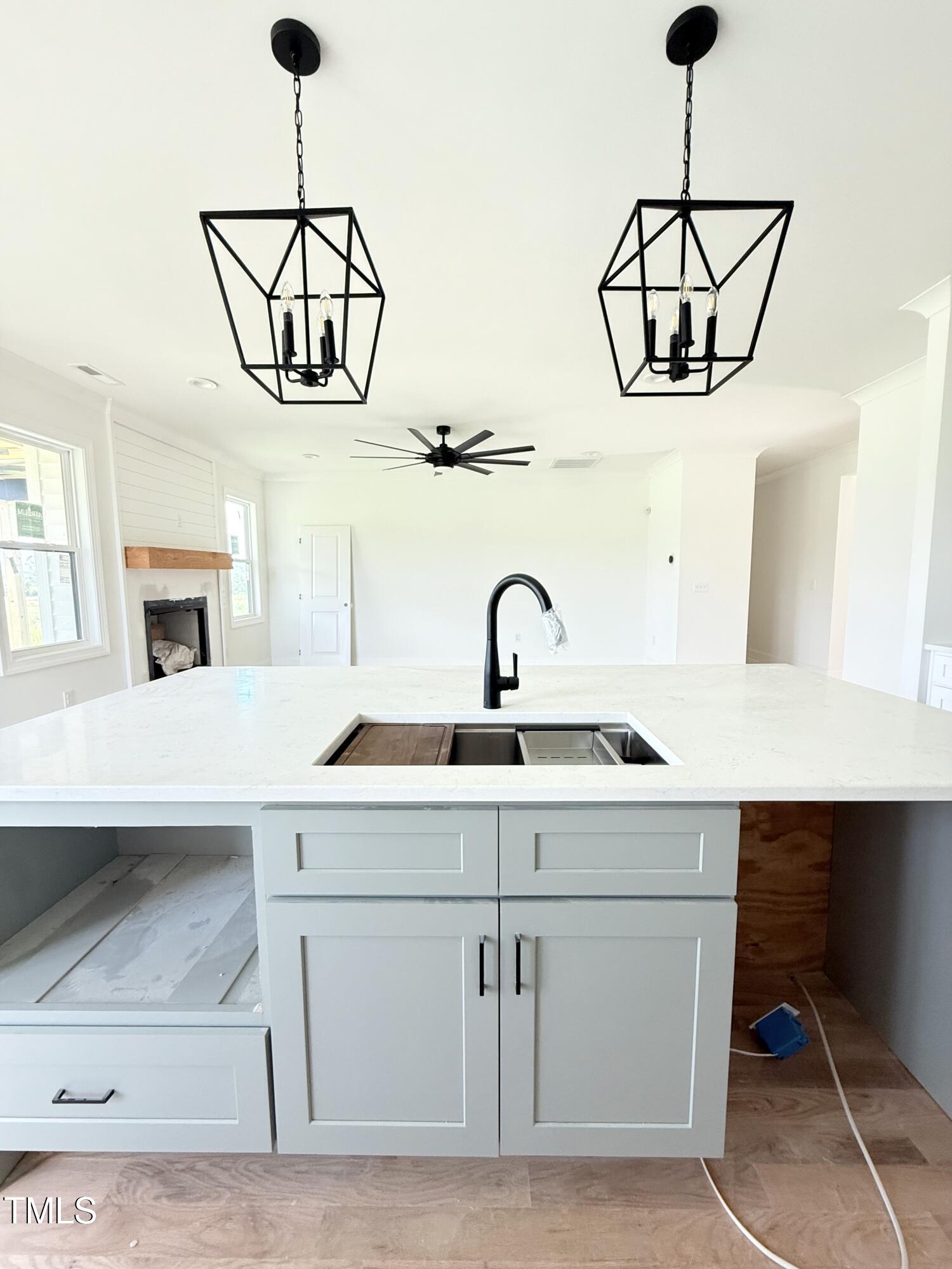 6930 Fire Tower Road Spring Hope, NC 27882 - Photo 6 of 33 a kitchen with a sink a chandelier stainless steel appliances and cabinets