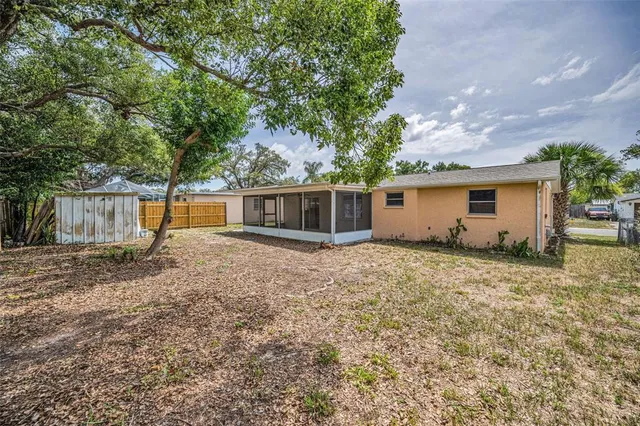 a view of a house with backyard and a tree