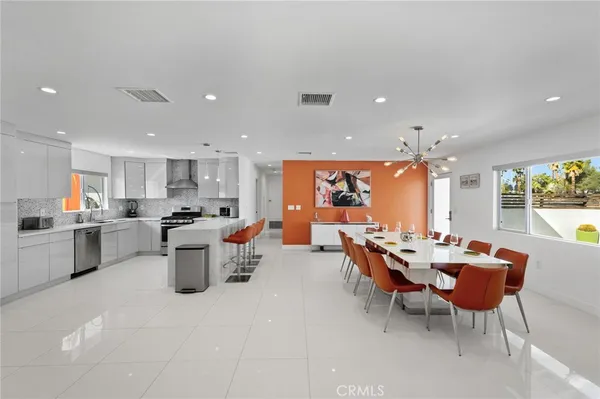 a view of a dining room and a kitchen with a table chairs