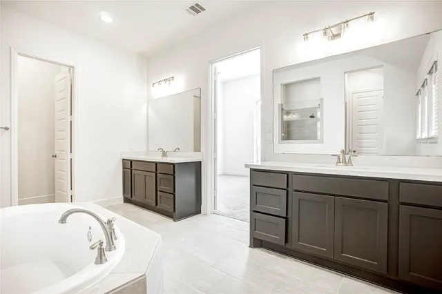 a white bath tub sitting in a bathroom near shower
