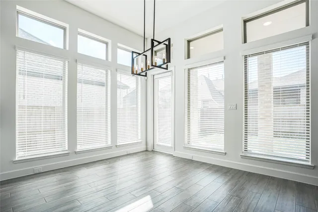 an empty room with windows and cabinet