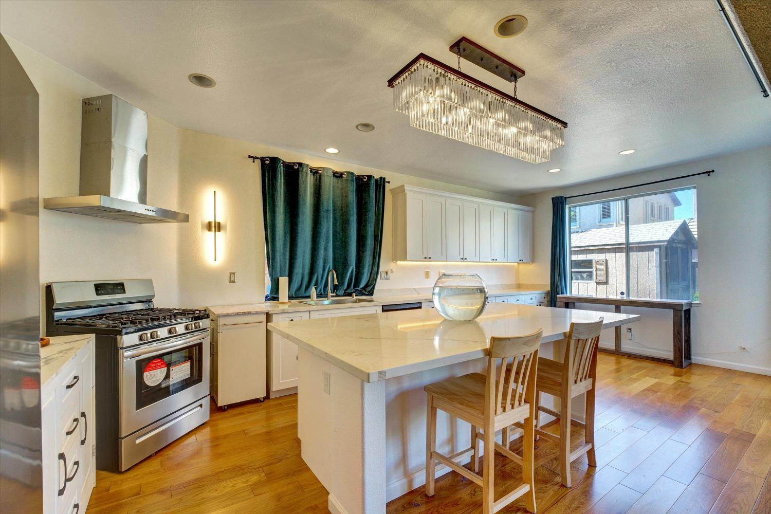 30253 Oakbrook Road Hayward, CA 94544 - Photo 5 of 49 a kitchen with stainless steel appliances granite countertop a stove a sink dishwasher a dining table and chairs with wooden floor