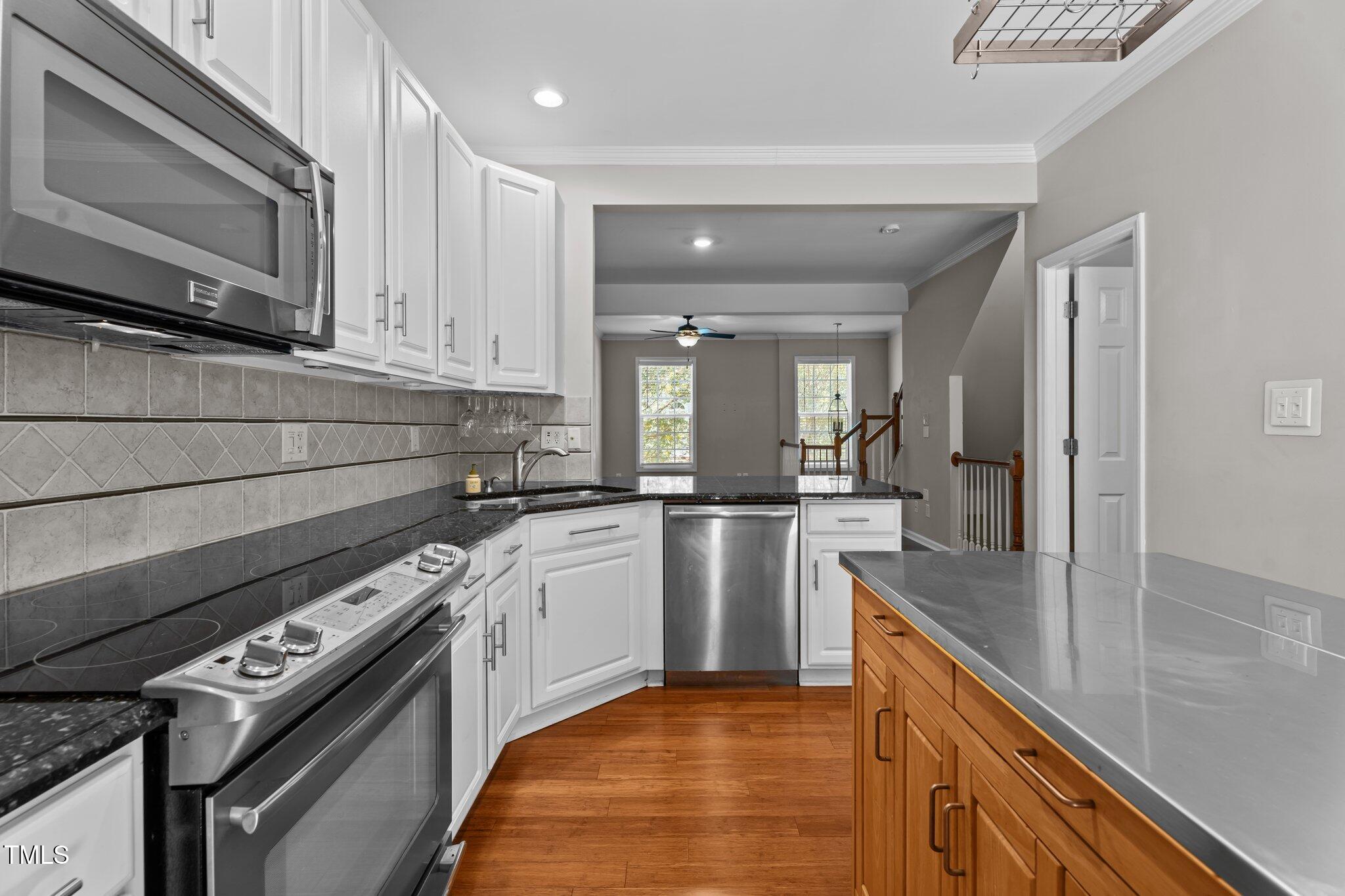 5310 Echo Ridge Road Raleigh, NC 27612 - Photo 10 of 29 a kitchen with stainless steel appliances granite countertop a sink a stove and a microwave