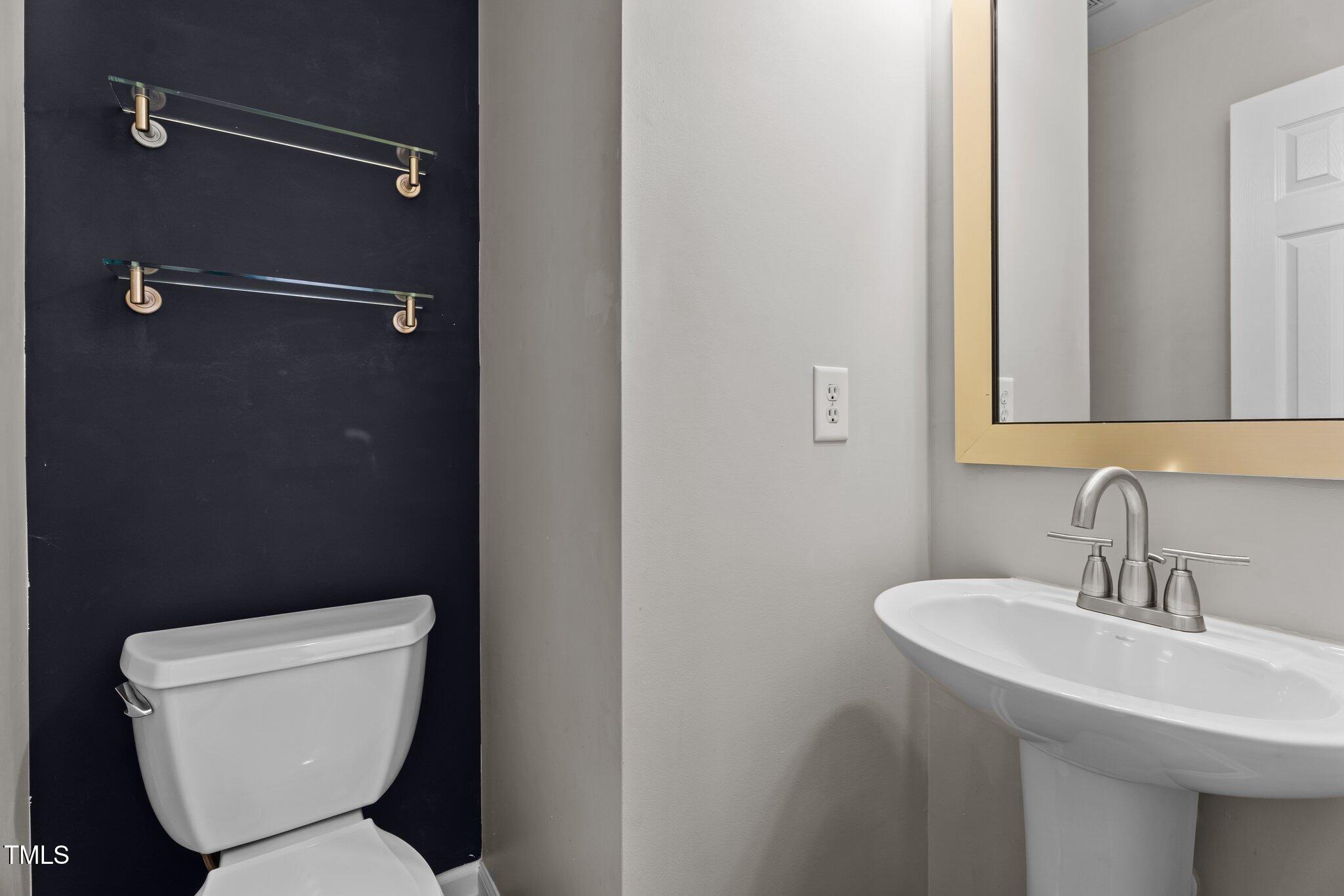 5310 Echo Ridge Road Raleigh, NC 27612 - Photo 13 of 29 a bathroom with a toilet sink and mirror