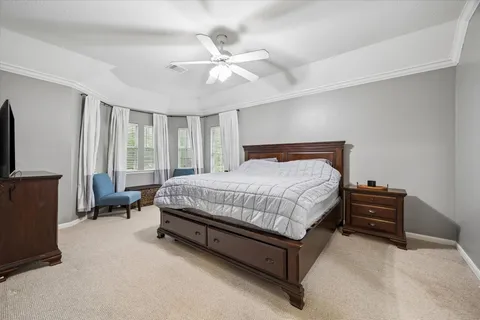 a bedroom with a bed couch and flat screen tv