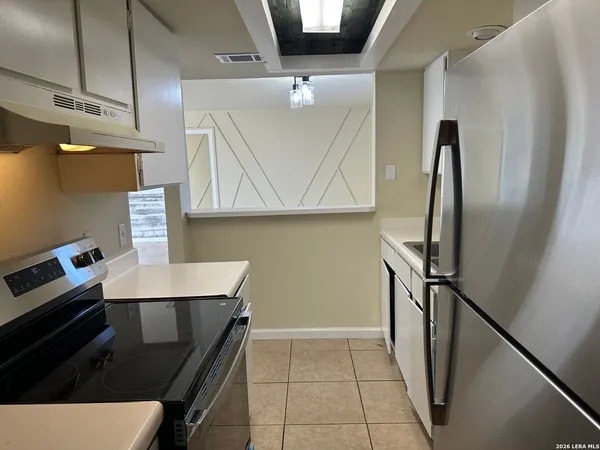 a kitchen with stainless steel appliances a refrigerator and a stove top oven