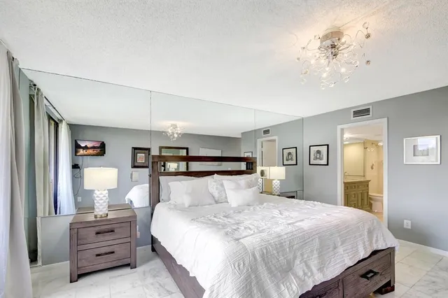 a bedroom with a bed and a chandelier